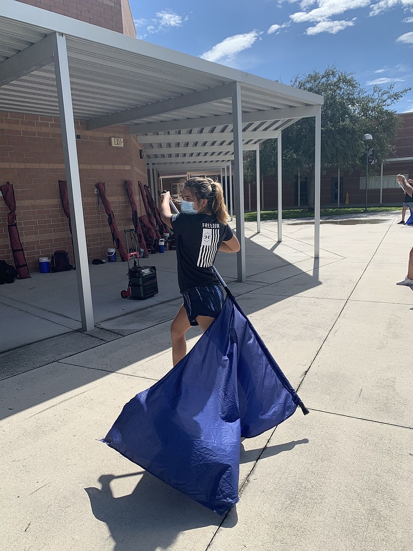 Sophomore Isabella Dreier practices with her flag as a member of the band's color guard. Courtesy photo.
