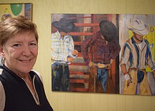 Deb Herbert stands in front of a oil painting she did at MJ Ranch in Myakka City.