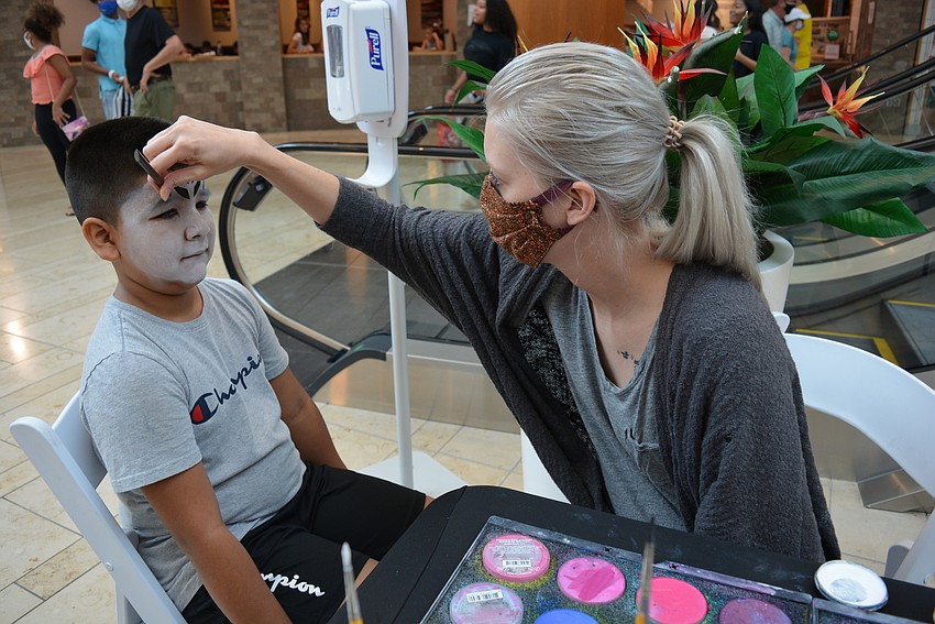 Kinnan Elementary's Giovanny Flores, 7, transforms into a white tiger at the hand of Enchanted Events' artist Cheyenne Dickinson.