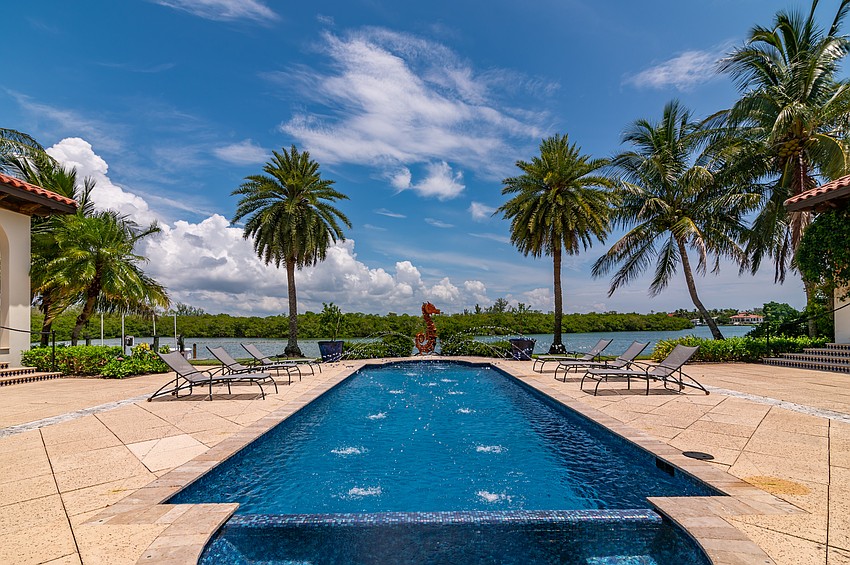 A courtyard and Romanesque swimming pool are located in the back of the home.