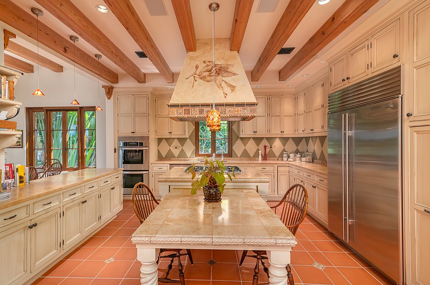 The kitchen features wooden beams and a large island.