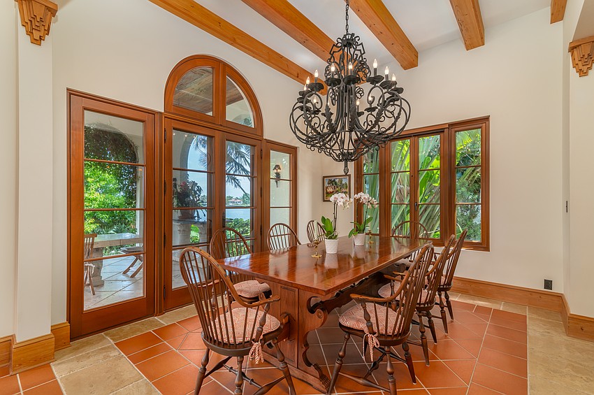 The dining room features wooden beams and an iron chandelier.