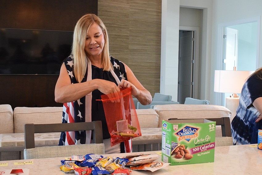 Lake Club resident Pat Ruggero packs snacks into a bag to give to deputies of the Manatee County Sheriff's Office.