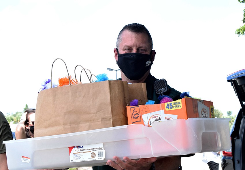 Deputy Scott Lindsey carries dozens of gift bags a group of Lakewood Ranch women made for deputies at the Manatee County Sheriff's Office.