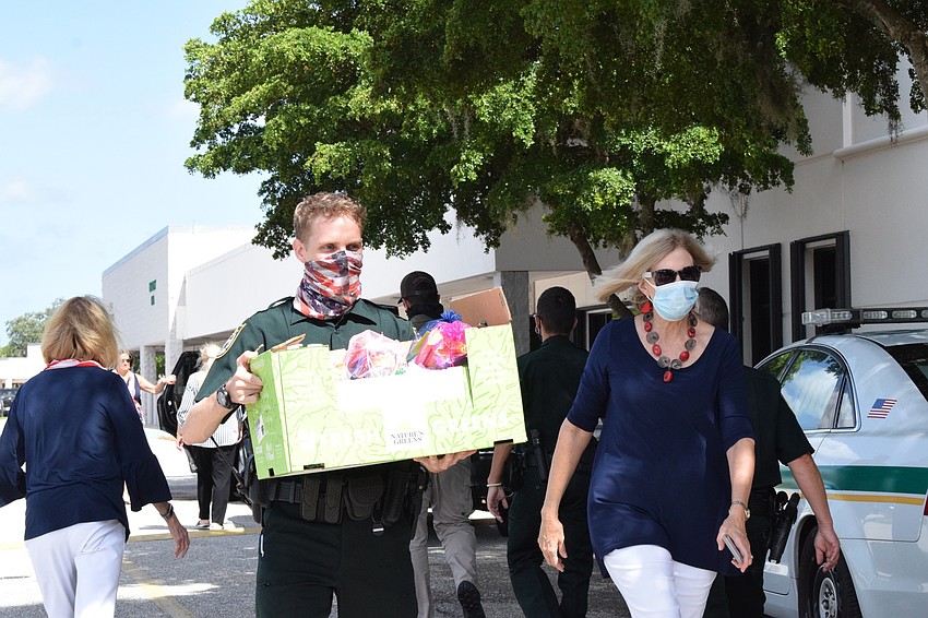 Deputy Reid Thomas with the Manatee County Sheriff's Office works with River Club's Carole Sullivan to unload 300 gift bags for deputies. The bags are filled with snacks and thank you notes.