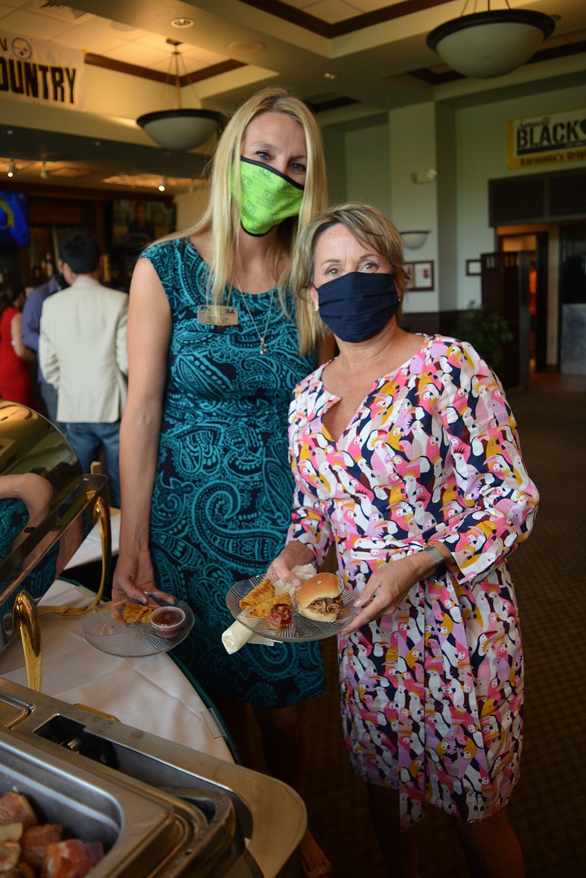 Lakewood Ranch Business Alliance past chairwoman Heather Williams and member Judy Atari grab dinner before sitting down for the Family Feud competition.