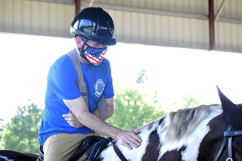 Dan Mohl shows love to Gallagher, the horse he's riding for his first lesson back at the Sarasota-Manatee Association for Riding Therapy since the pandemic began. 