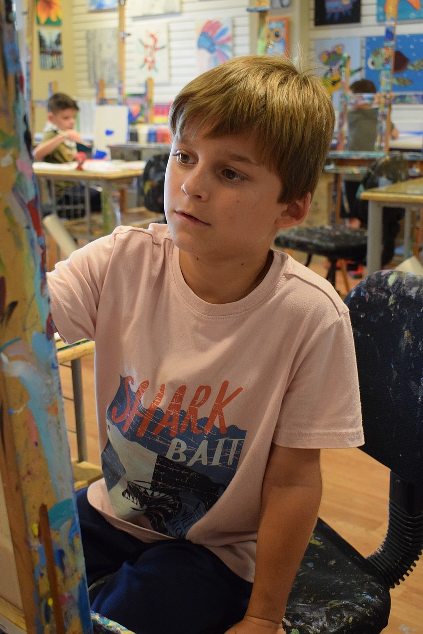 Gregory Sheaperd, a third grader at Providence Community School, paints the background of his painting white. He painted his ice cream a mint color to represent mint chocolate chip ice cream.