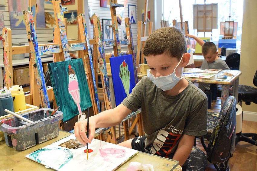 Ben Kloss, a third grader at Providence Community School, adds a cherry on top of his ice cream sundae.
