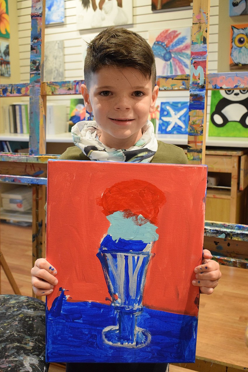 Beckham Buchanan, a first grader at Providence Community School, shows off his finished artwork.