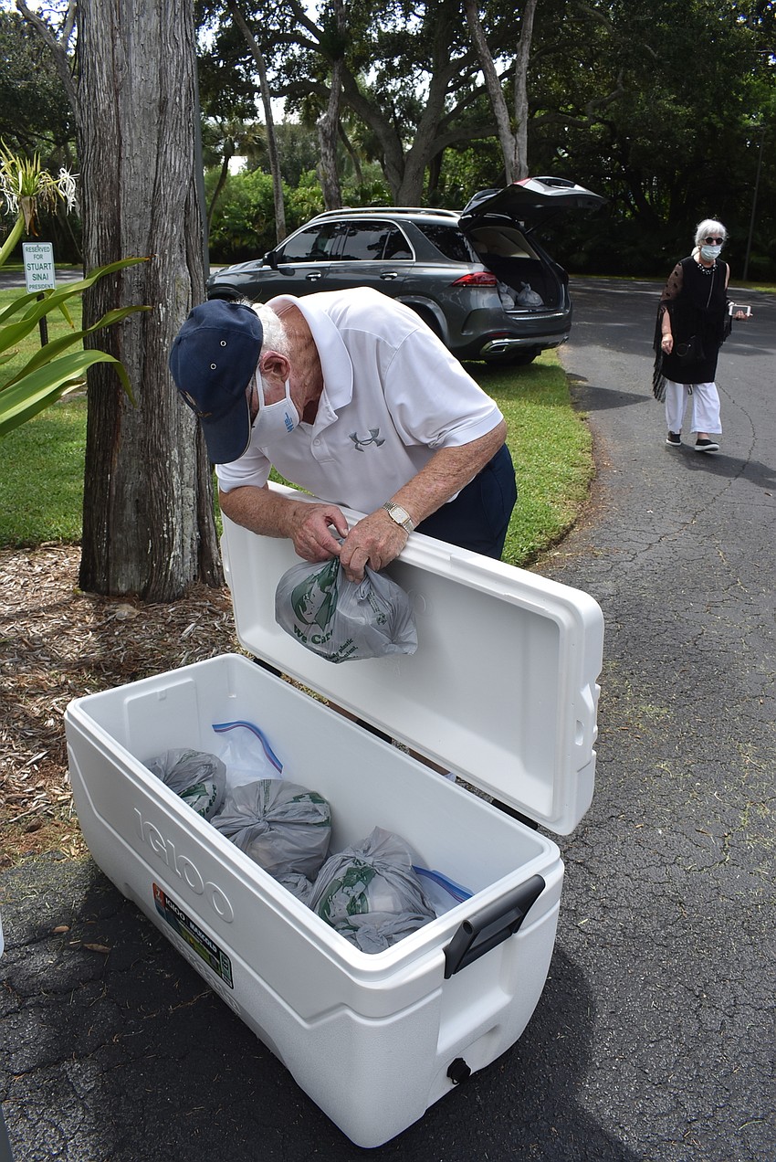 Lewis Moyer organizes meals, which are kept cool in the withering heat.