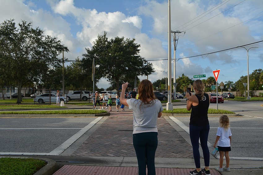 Kim Alvarez waves goodbye and Sumer Creasy snaps photos ahead of the first day of school at Fruitville Elementary. David Conway