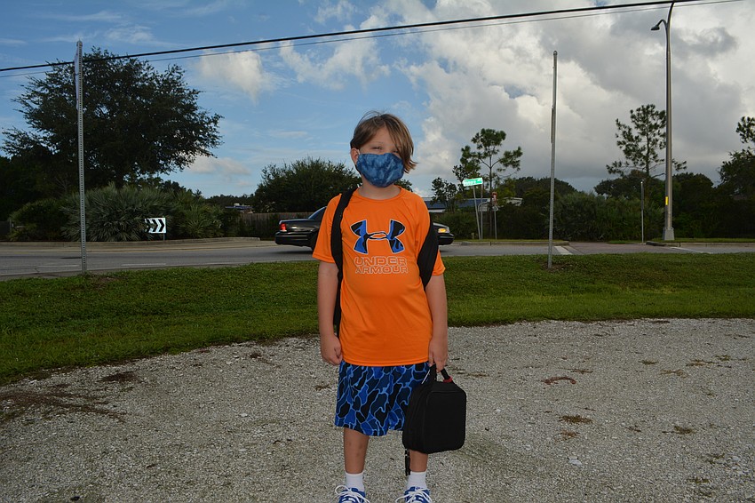 Fruitville Elementary student Luke Simmons carries his lunchbox and Pokémon backpack for the first day of class. David Conway