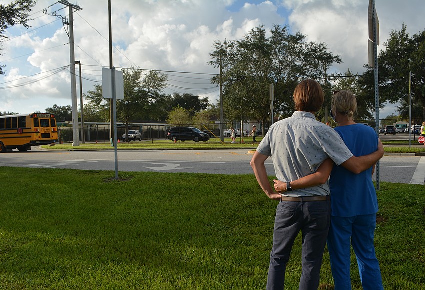 Evan and Stephanie Barniskis watch as their child begins the first day of kindergarten. David Conway
