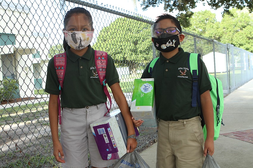 Emily Barragan, 10, and Hector Barragan, 9, bring their favorite supplies to Alta Vista Elementary School.  Harry Sayer