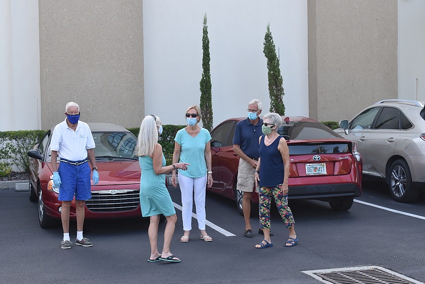 In the parking lot, friends caught up after determining each other's identity through their masks.
