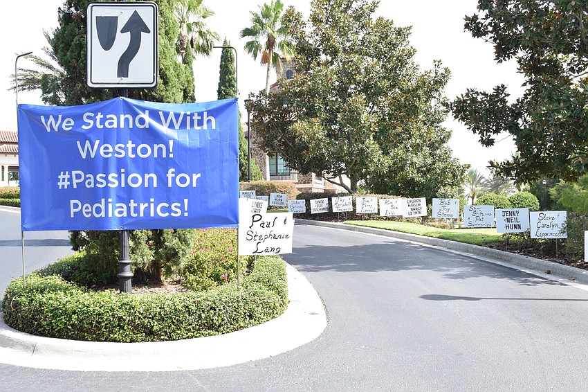 The road up to The Lake Club Grande Clubhouse was covered in a sea of white signs with names of people who made donations to the drive thru fundraiser.