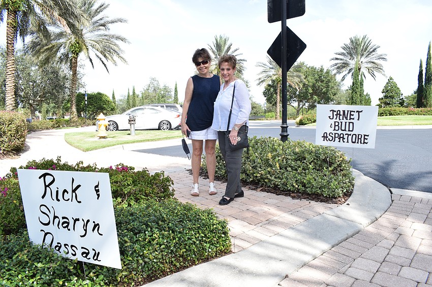 The Lake Club's Stephanie Lang and Janet Aspatore view the hand-written signs they created for the fundraiser. Each sign has the name of a donor.