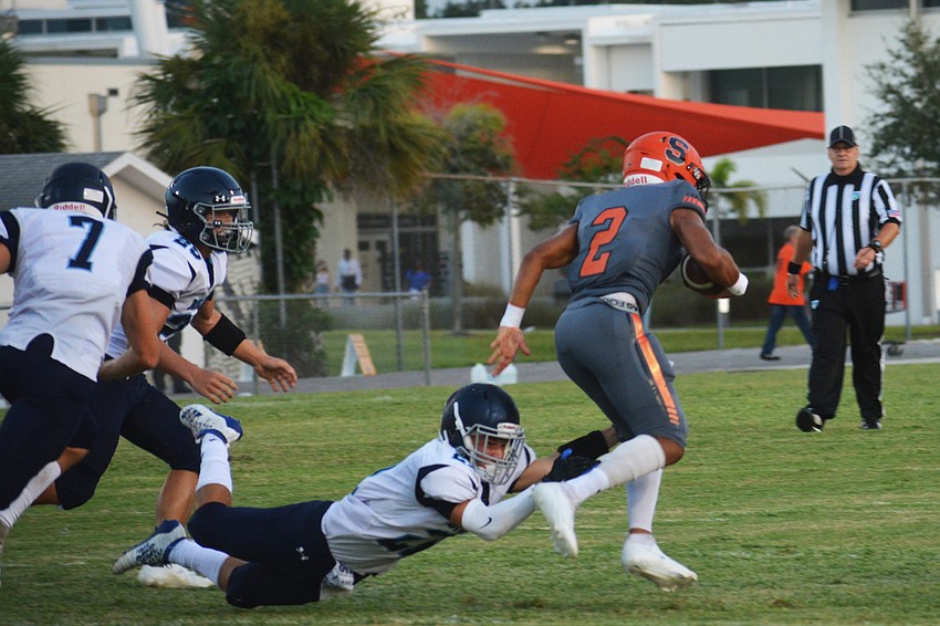 Sarasota quarterback Dominic Bennett evades a defender on a scramble.