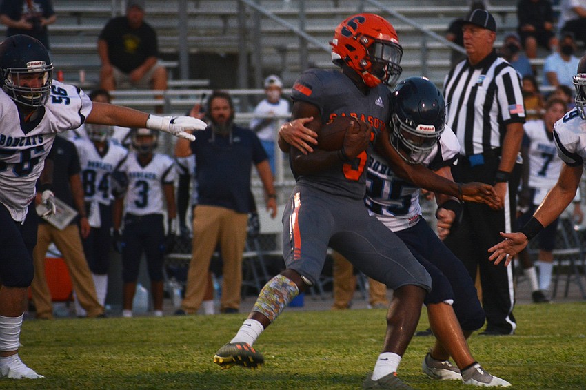 Sailors running back Jamel Holloway spins through a defender's attempted tackle.