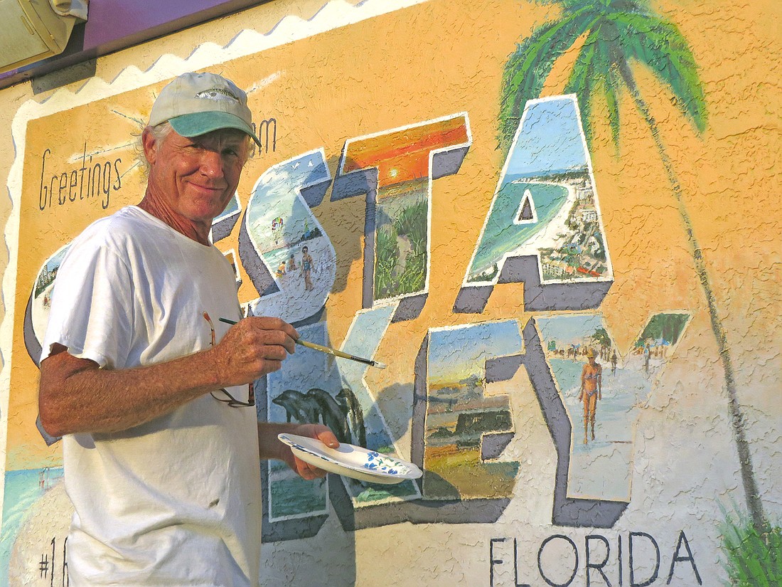 Shawn McLoughlin paints a mural welcoming people to Siesta Key. Photo courtesy