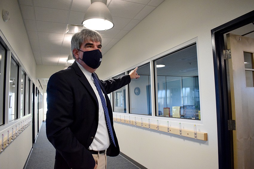 David Mahler, The Out-of-Door Academy's head of school, explains the collapsible walls so two classrooms can become one as students tour the new facility.