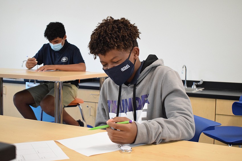 Frankie Clark, an eighth grader, is drawing out an idea from his homework assignment. Clark is sitting in a classroom in the new middle school facility.