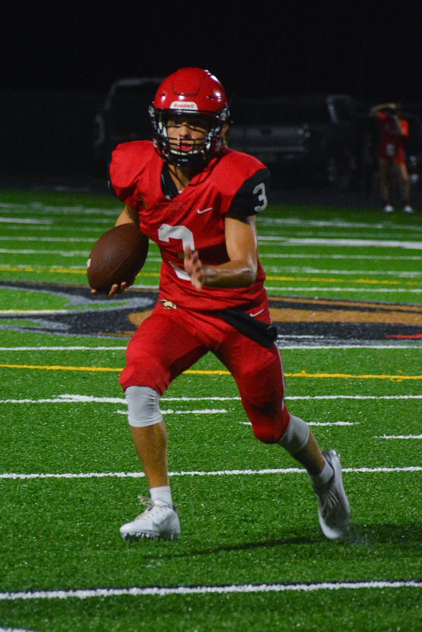 Cougars quarterback Tayven Clark looks downfield to find a receiver.