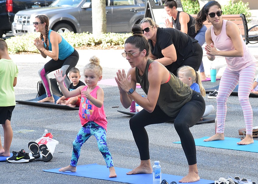 Lakewood Ranch's Dallyn Doehr, who is 4 years old, does squats with her mother, Alexx Doehr. Dallyn Doehr enjoyed doing the big stretches.