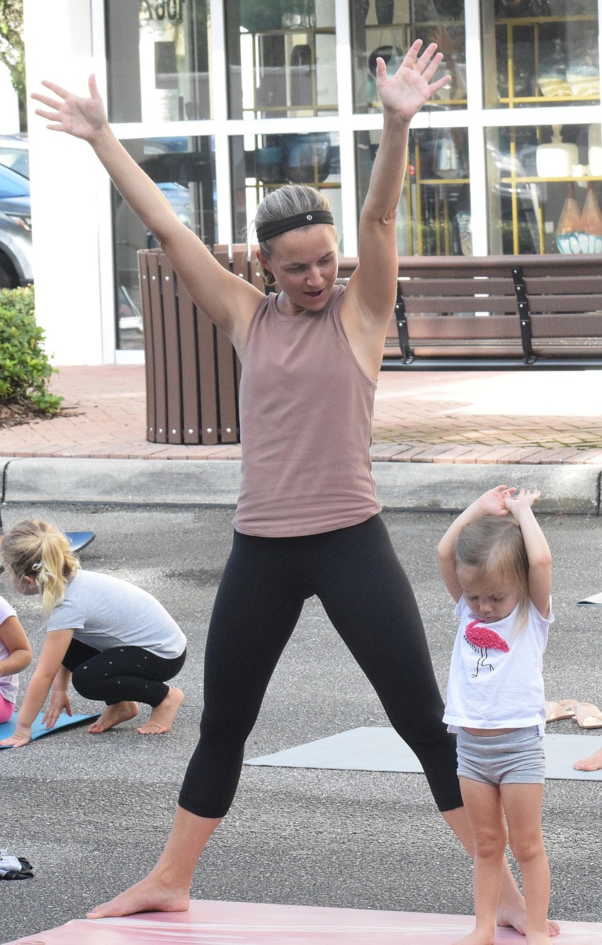 Lakewood Ranch's Lindsey Hassett reaches to the sky while watching her 2-year-old daughter Everly do the same.