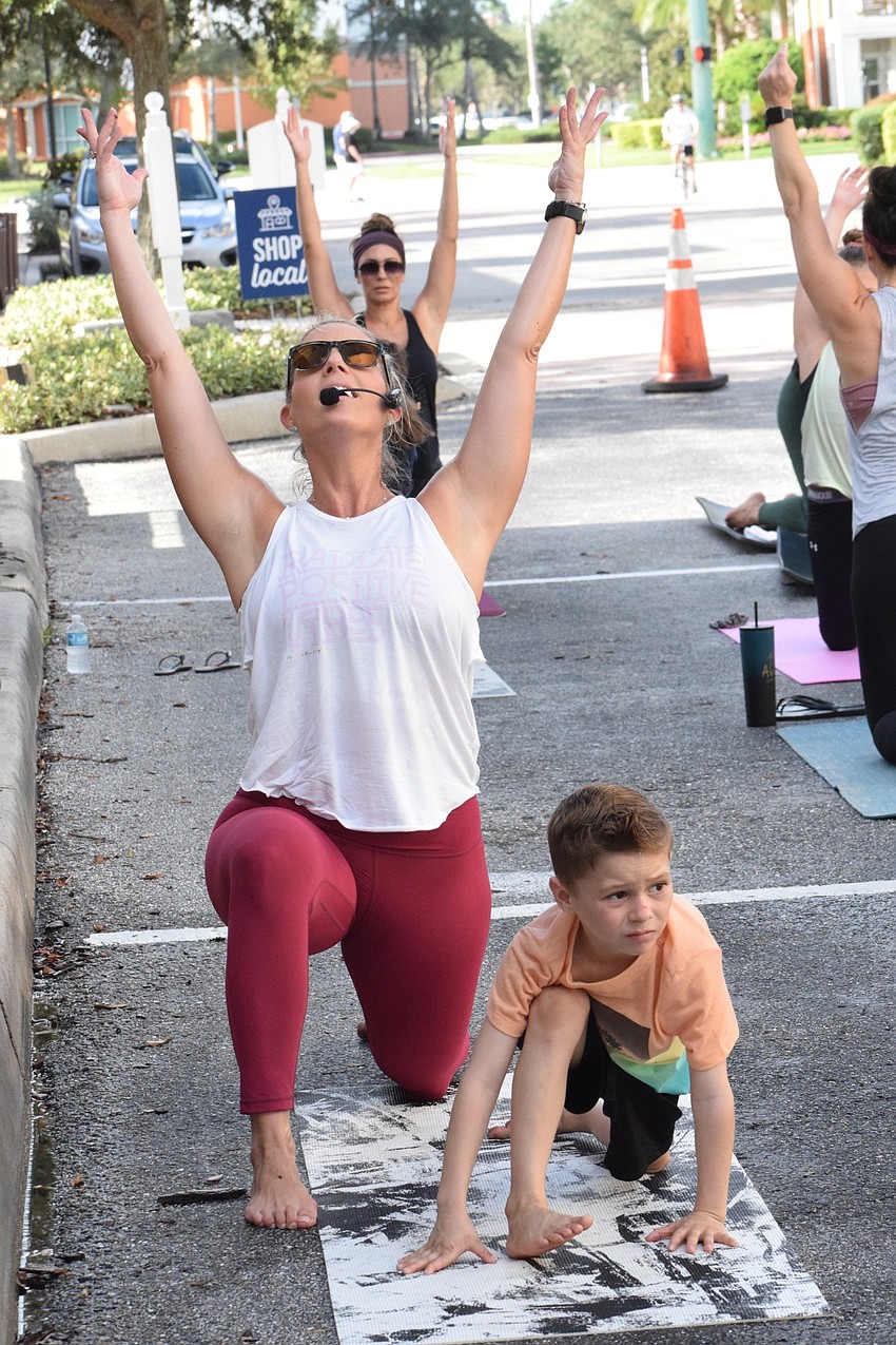 Barre3 instructor Jenna Phillips leads the group with her 6-year-old son Jackson Phillips by her side.