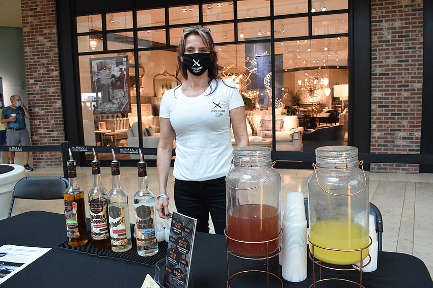 Alana Morley, a tasting room specialist with Loaded Canon Distillery, hands out samples to Women's Day Expo participants.