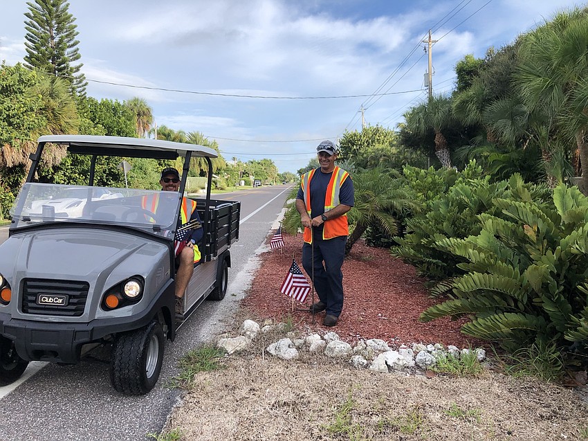 Charlie Mopps sits in the cart while Frank Scrivani plants flags. Courtesy photo.