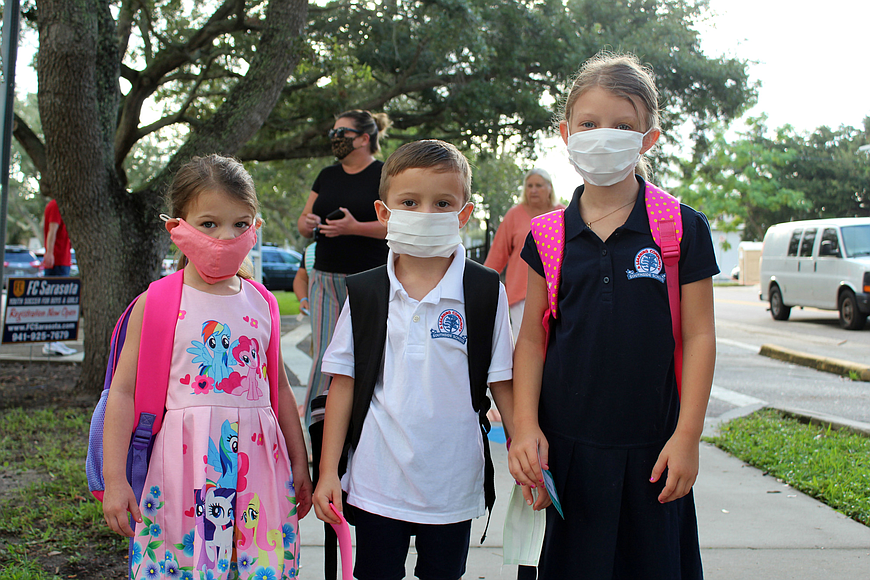 Lily, Mason and Cassidy Berg show off their masks before heading into Southside Elementary School.
