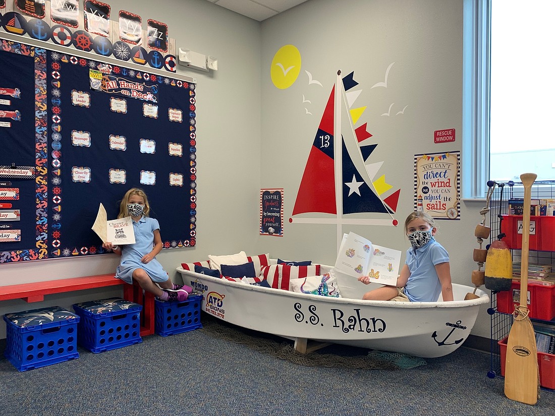 Second graders Ella Baas and Aubri Darpino spend time reading in second grade teacher Laurie Rahn&#39;s nautical themed classroom. The seafoam color of the classroom adds to Rahn&#39;s theme, Rahn says.