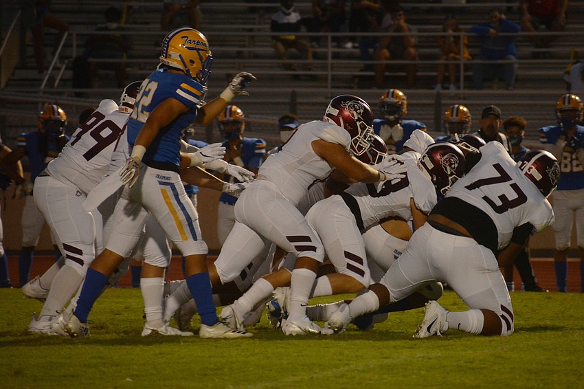 The Pirates defense, led by nose tackle Albert Dowling (73) crush a Charlotte running back in the hole.
