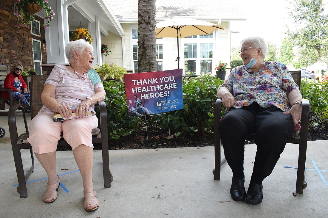 Jeanne Klein and Sue Seuell, residents of Cypress Springs Gracious Retirement Living, laugh while talking to each other. "I&#39;m happy I can be outside and get fresh air," Klein says.