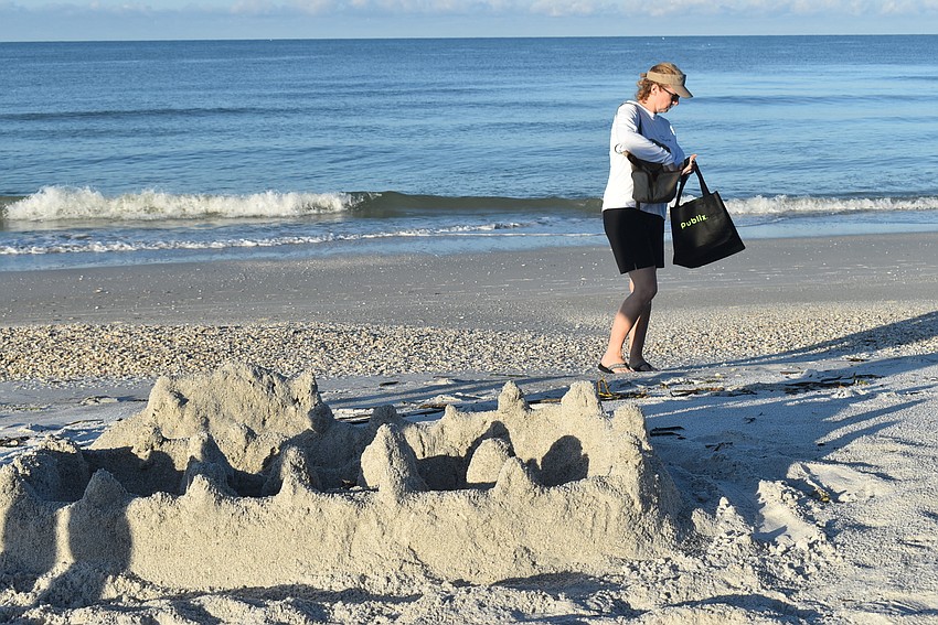 Carlyn Vigil finds her first piece of trash near a sandcastle.