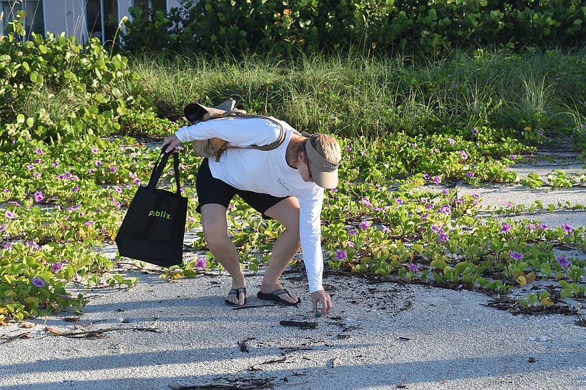 Carlyn Vigil grabs trash.