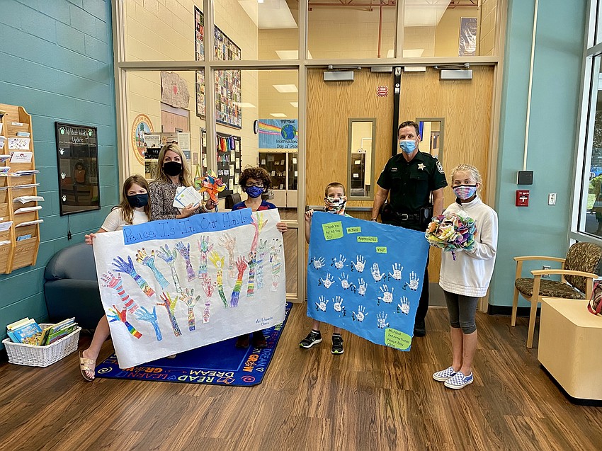 Ella Dyer, Kristi Dyer, effrey Davis and Keagan Terry, Detective Todd Shear and Isabella Lawton show off the banners students made to give to local law enforcement. Courtesy photo.
