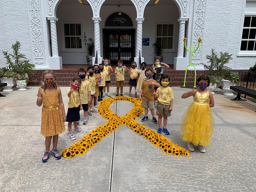 Students take photos near a sunflower ribbon as part of the fundraiser's activities. Photo courtesy