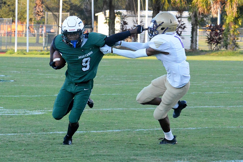 Mustangs junior wideout Jaleel Duncan stiff arms a Booker defender.