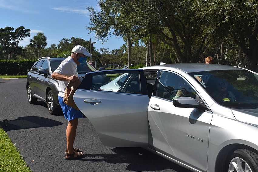Paul Skversky lifts donations out of a member's car.