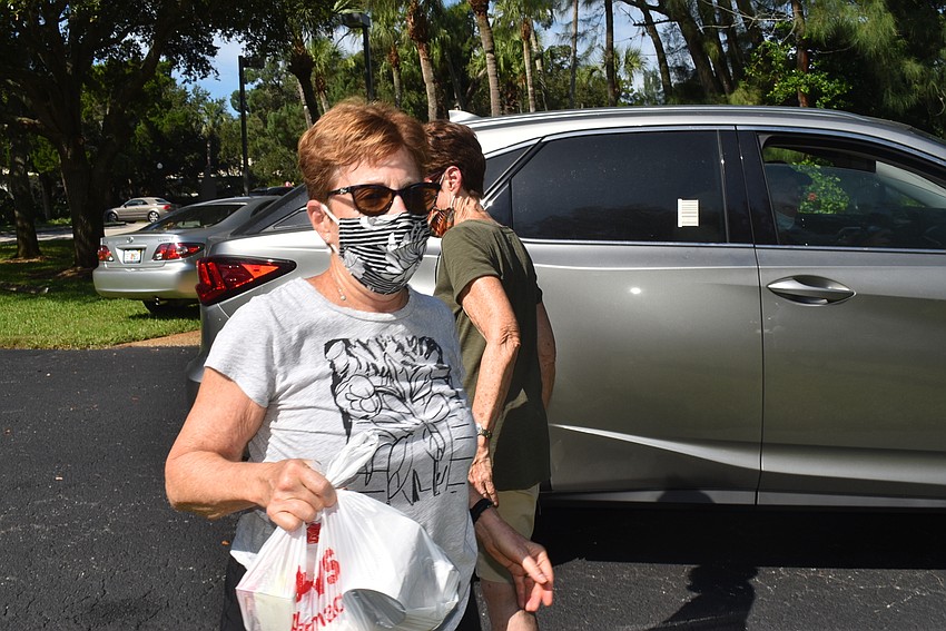 Debbie Nyman carries donations to a car waiting to head to Second Chance Last Opportunity.