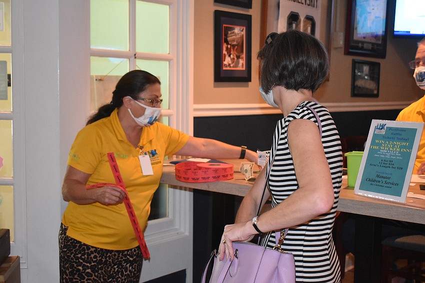 Debbie Shaffer sells raffle tickets to Sharon Gould.