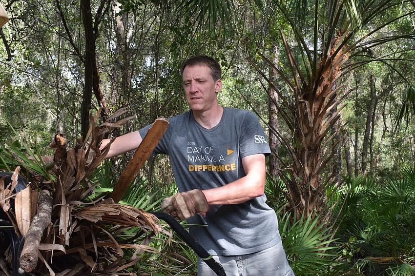 Erik Phelps with Smith Seckman Reid loads a golf cart with debris to clear the sidewalks around the camp grounds.