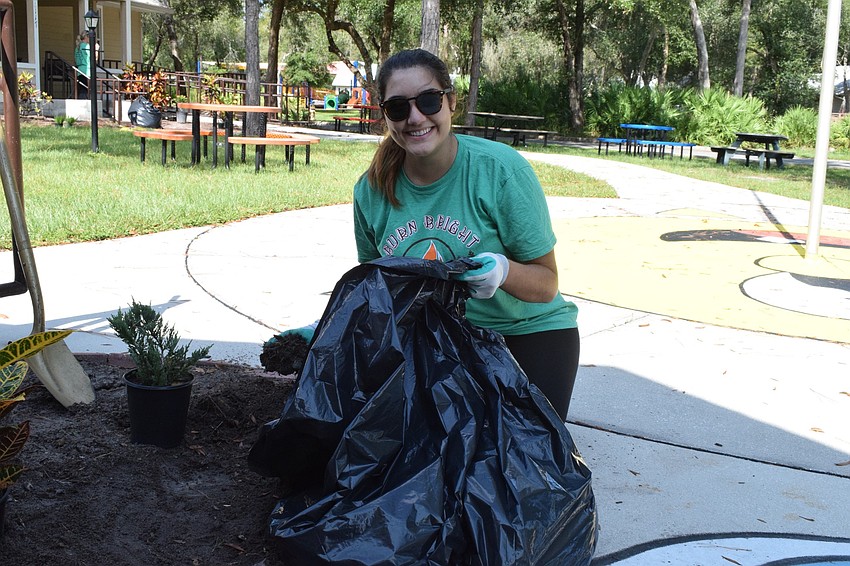 Margaret Sanchez with Sokos Social helps with planting. 