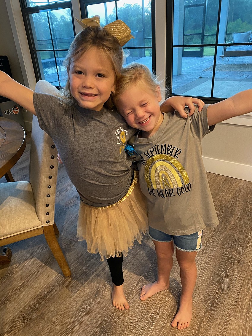 Panther Ridge's Charlotte Wells and her sister Savannah Wells wear the shirt that spread awareness about childhood cancer for Go Gold Day.