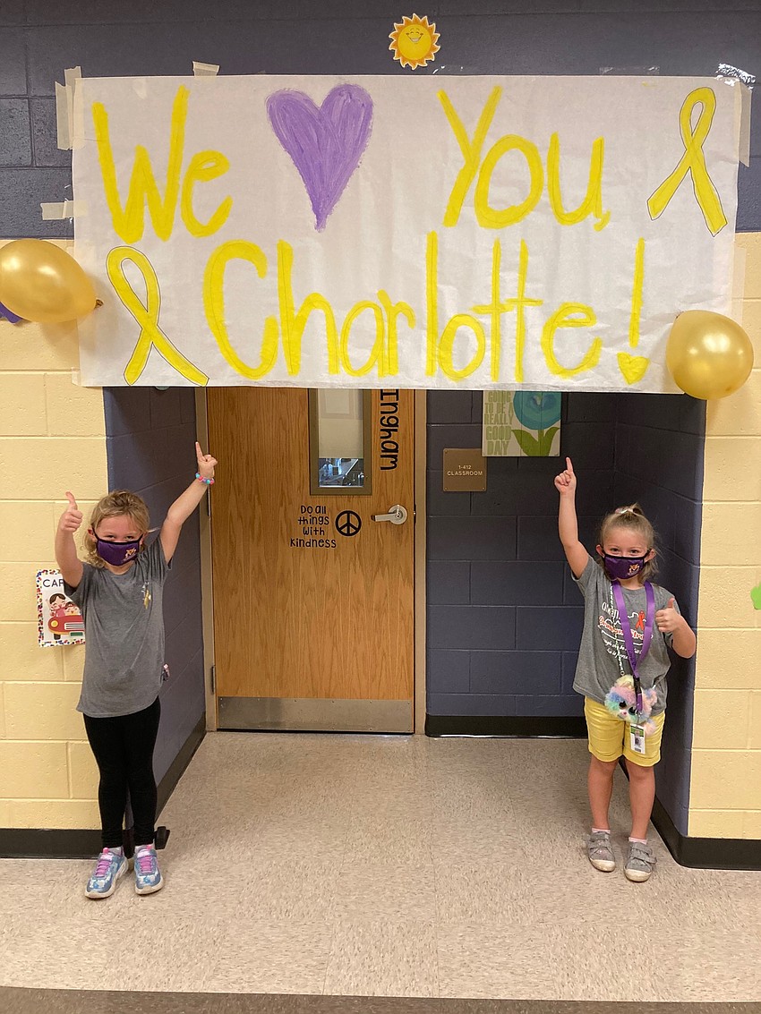 Charlotte Wells, a first grader at Gilbert W. McNeal Elementary School, enjoy Go Gold Day at school with Layla Vaughn.