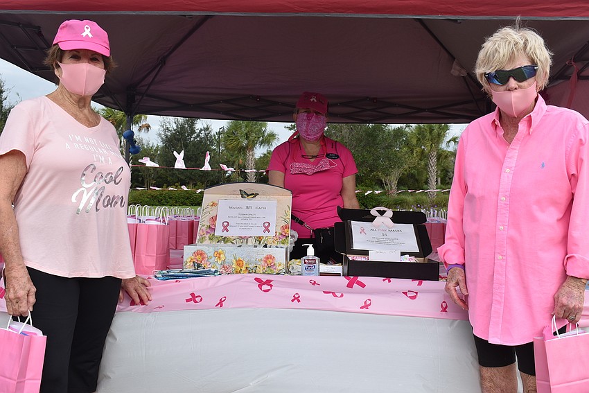 Carole Klase (left) and Carol Roberts (right) browse a collection of masks made by Chris Fulford (center). The masks cost $5 each.